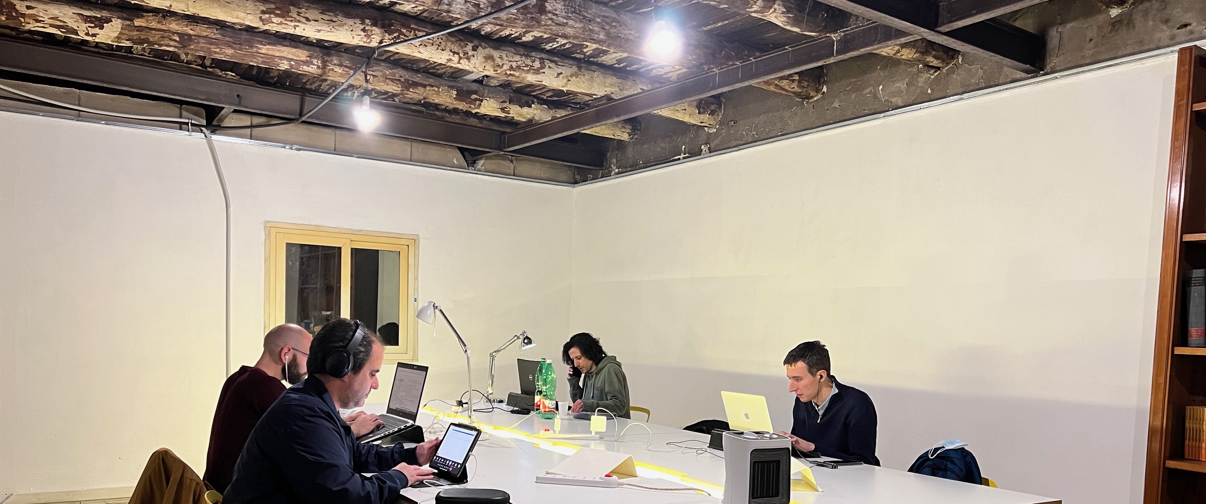 People working in a room with the original wooden beams